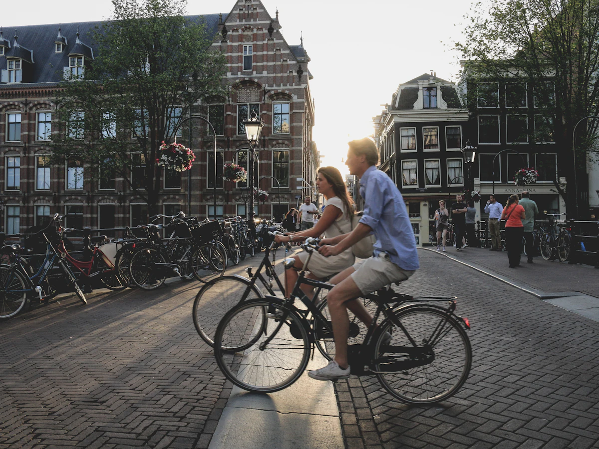 A man and a woman cycling together through Amsterdam