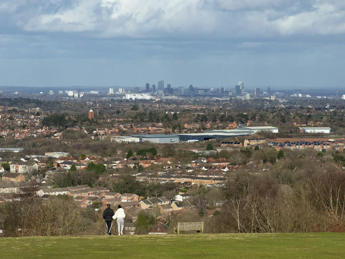 Two people looking out over Birmingham from a hilltop