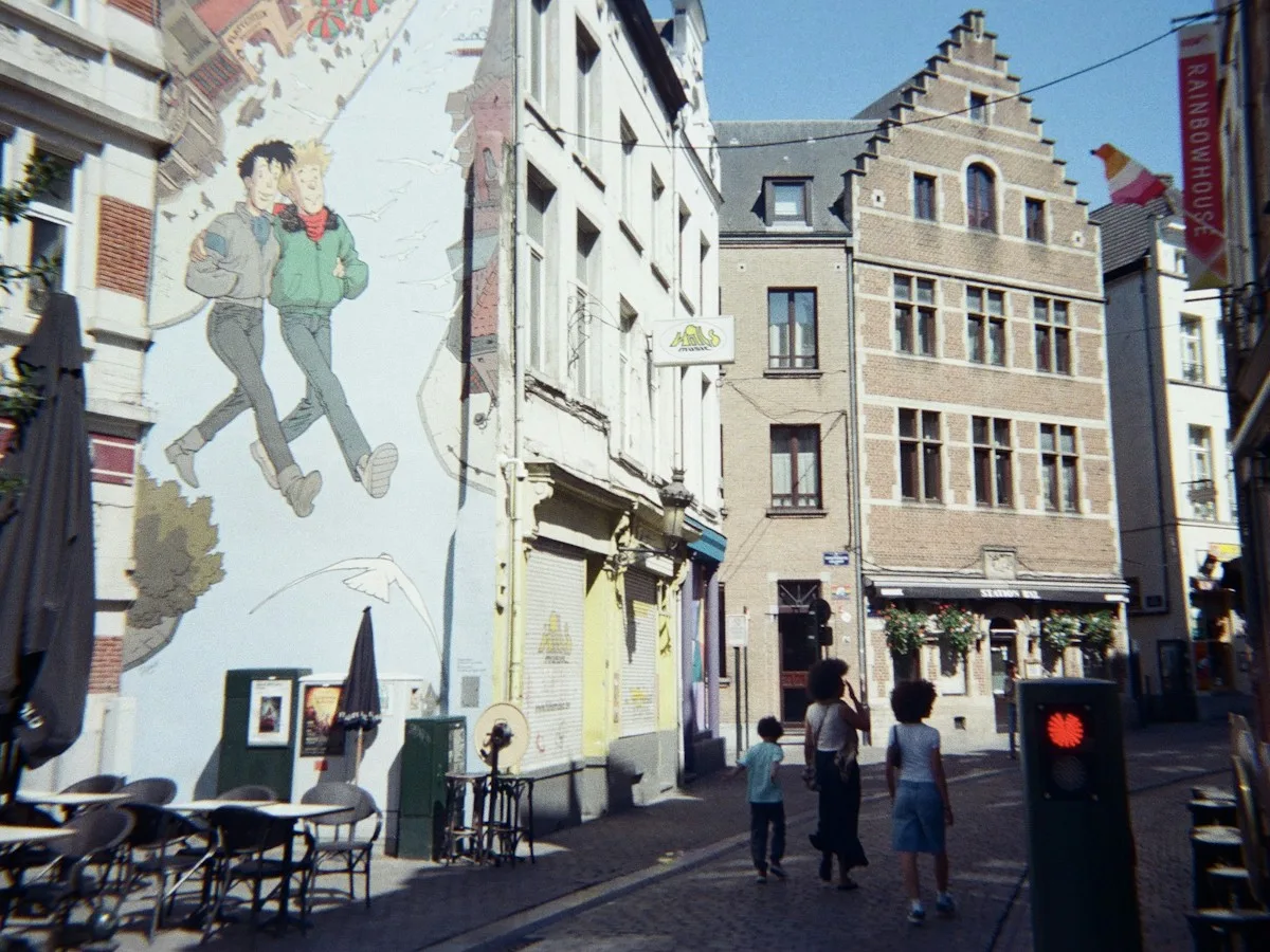 People walking past a comic-strip mural in Brussels