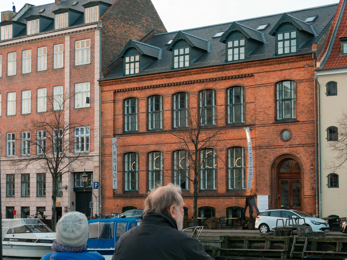 Two people sitting on a bench by a Copenhagen canal