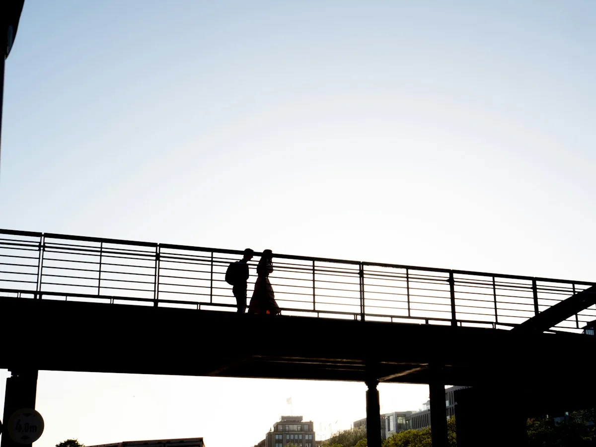Silhouettes of two people walking across a bridge in Hamburg