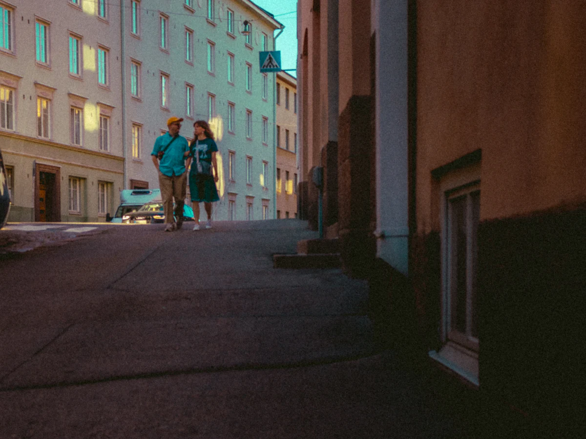 A couple walking down a Helsinki street at dusk