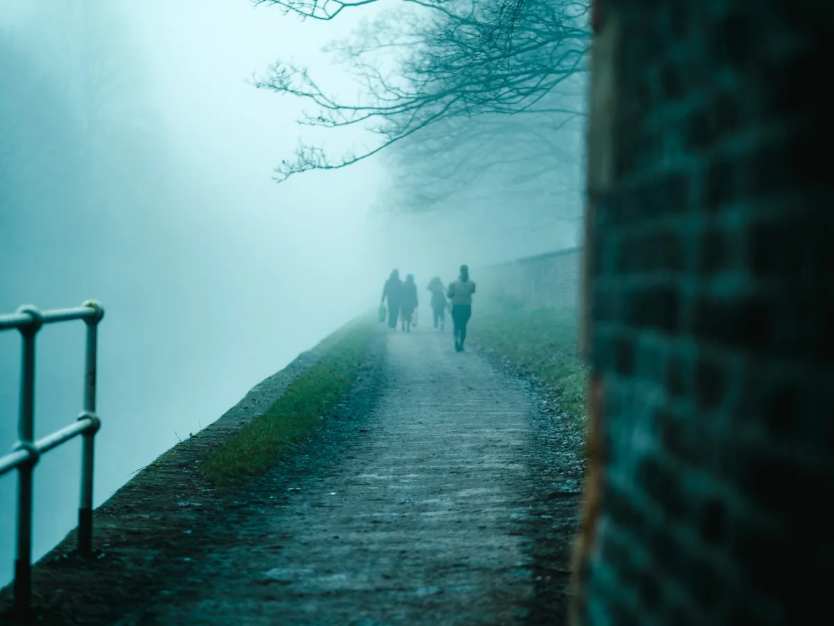 People walking along a foggy canal towpath in Manchester