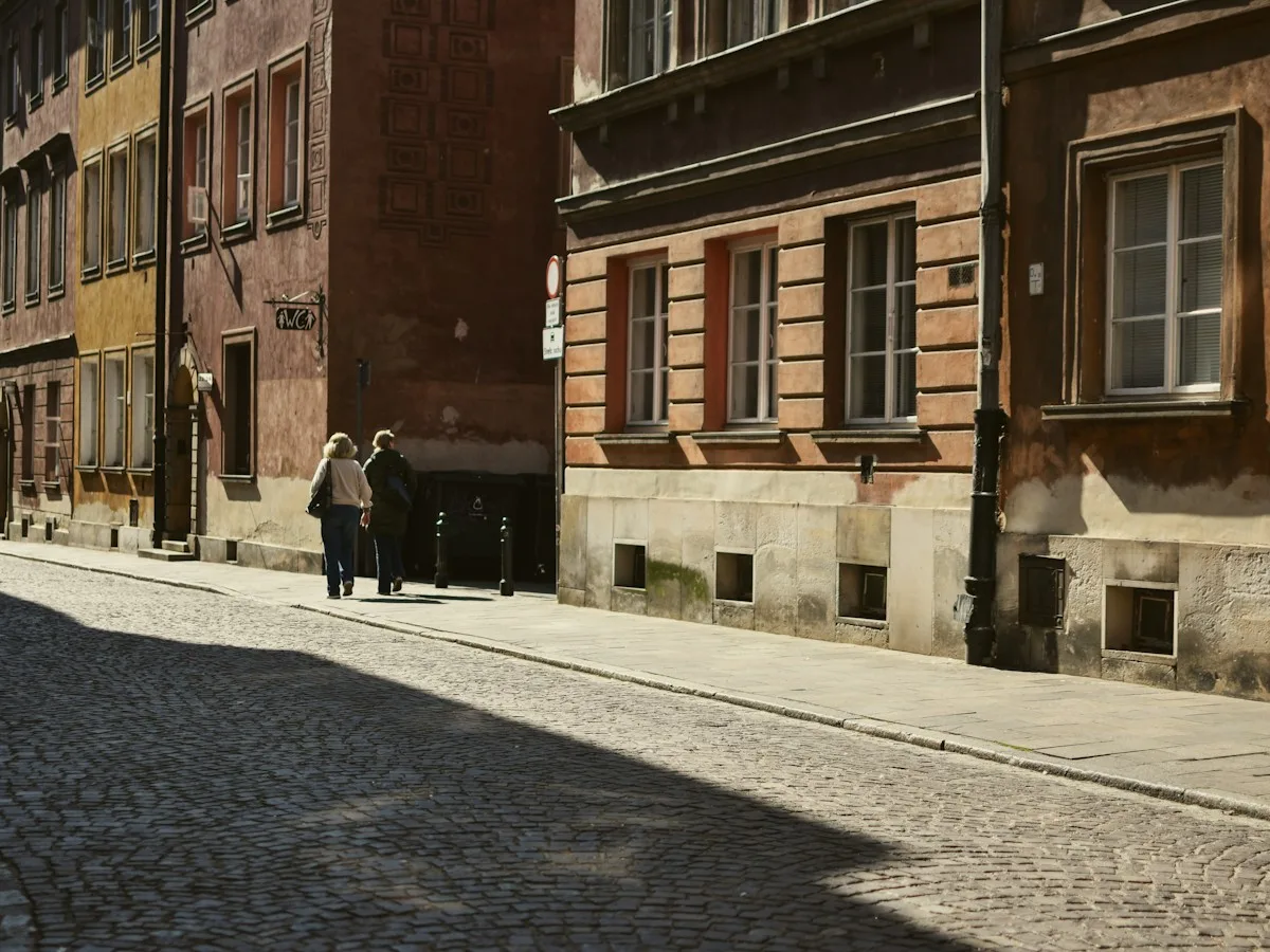 People walking down a sunny street in Warsaw’s Old Town